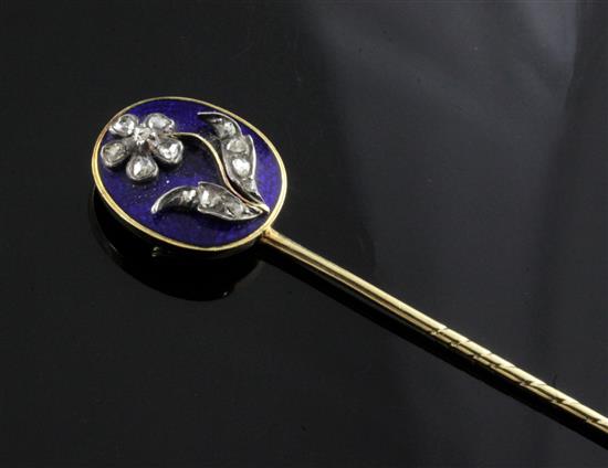 A late Georgian yellow metal and blue enamel stick pin, the oval head set with rose diamonds in a flower motif and with hairpiece back
